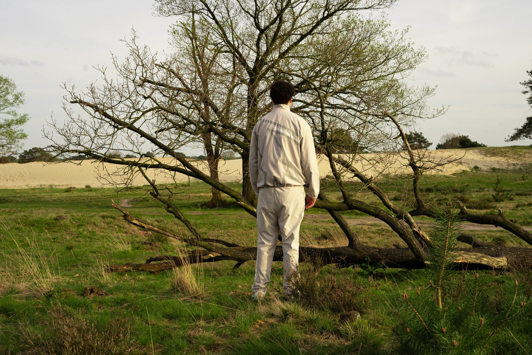 Model von hinten vor einem umgestürzten Baum